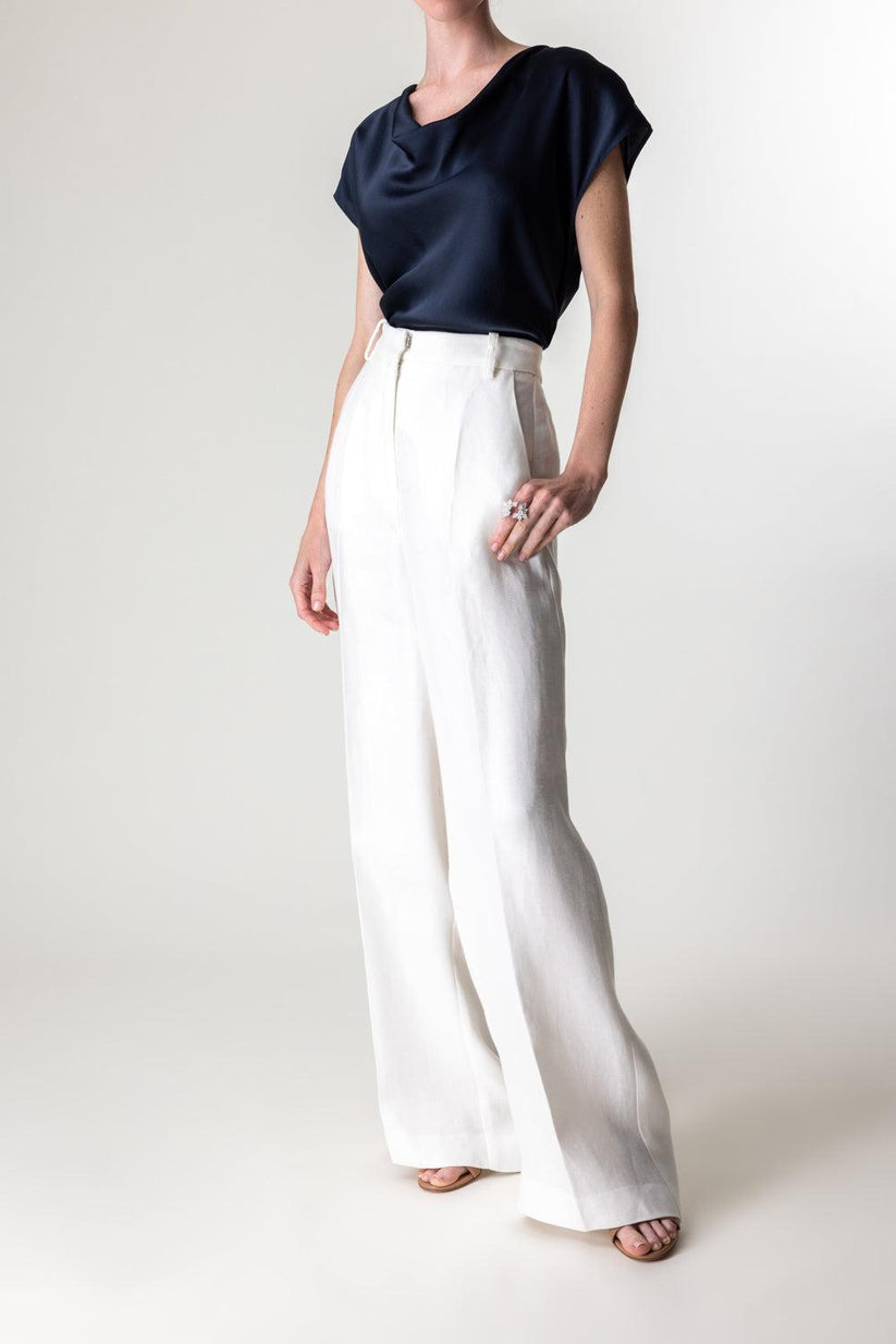 a woman wearing white pants and a black top