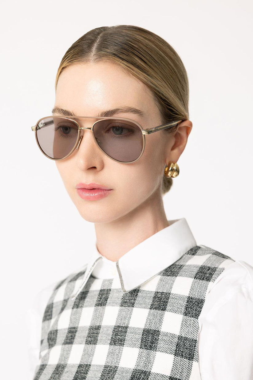 a woman wearing sunglasses and a white shirt