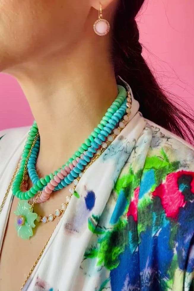 a woman wearing a colorful shirt and necklaces